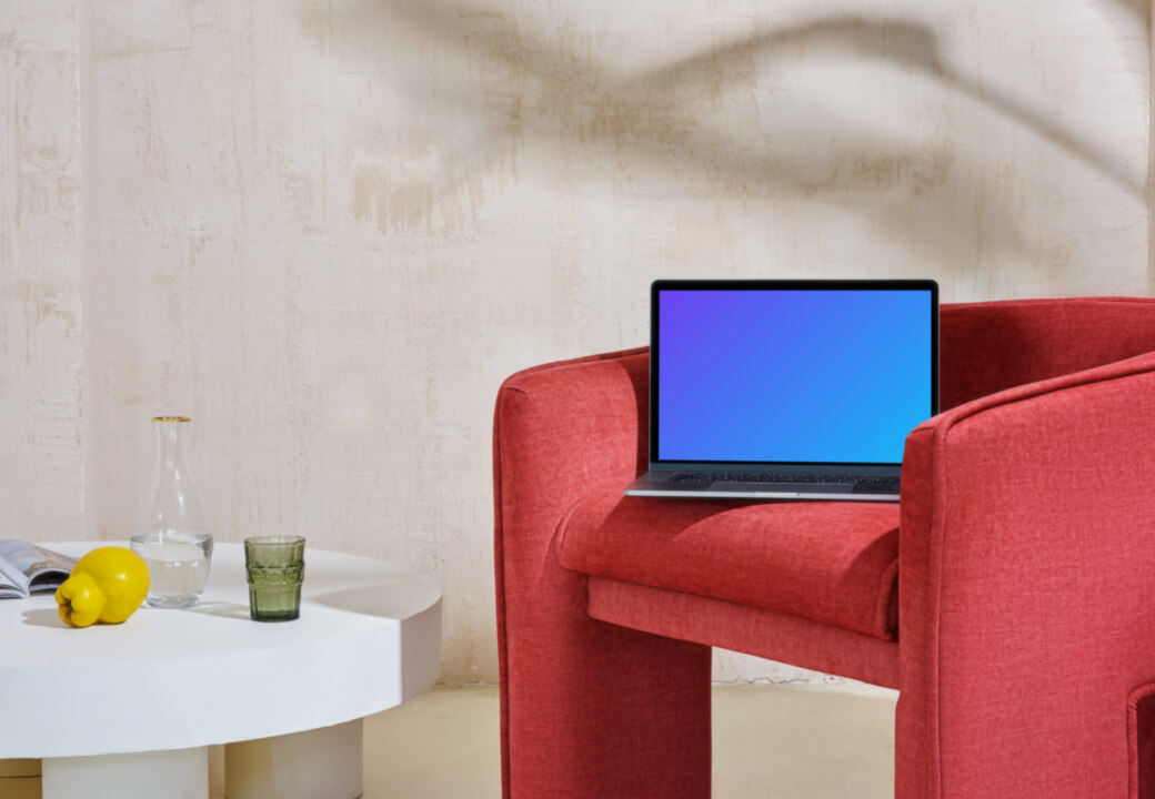 MacBook mockup sur un canapé rouge