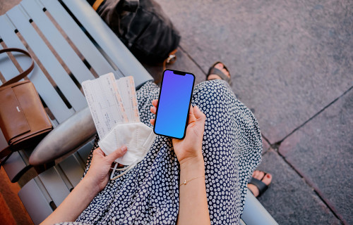 Woman holding iPhone mockup and train tickets