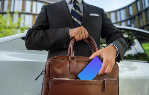 Businessman putting his phone into the work bag