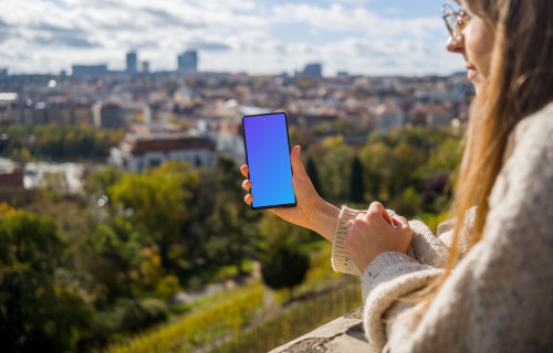 Female holding a Google Pixel 6 with city view mockup