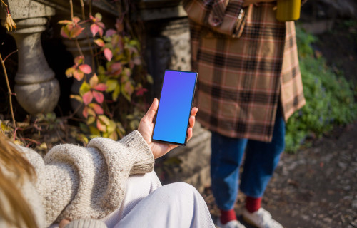 Hand holding a Google Pixel 6 in the park mockup