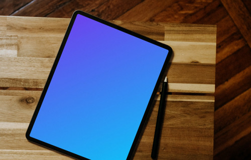 iPad mockup with pen on wooden desk