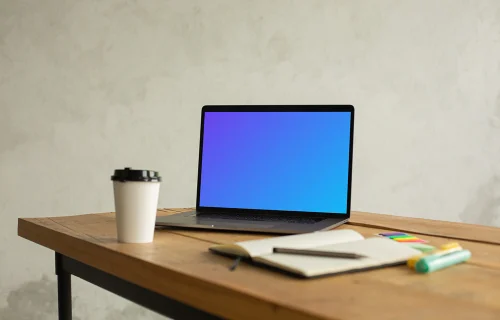 MacBook Pro mockup on a table beside a cup of coffee