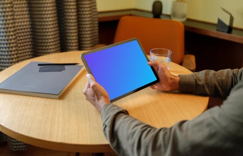 Man holding a iPad mockup in the lounge