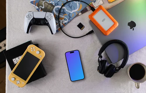 Smartphone mockup with gaming gear on a creative desk