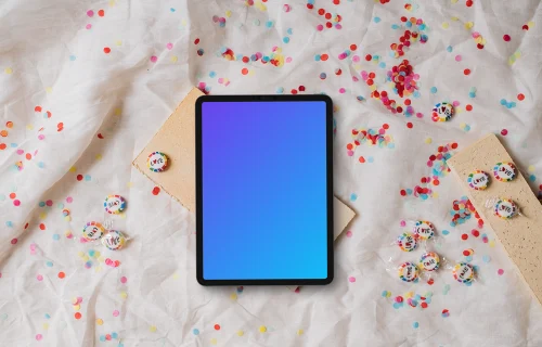 Tablet mockup on a white fabric with confetti and candy