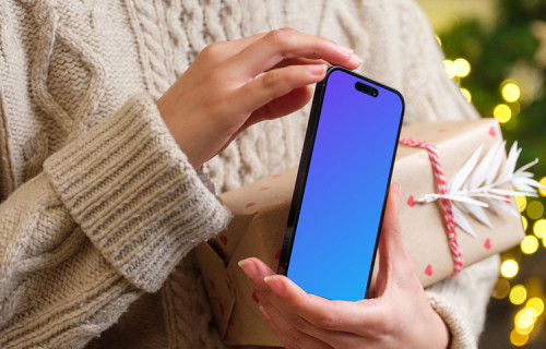 Woman holding a phone mockup in Christmas theme