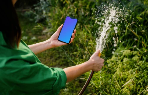 Woman holding an iPhone while watering plants mockup