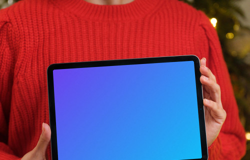 Femme en pull rouge tenant une tablette mockup