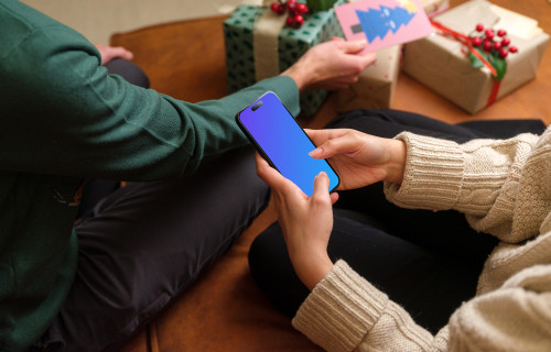 Femme entourée de cadeaux de Noël et tapant sur son téléphone mockup