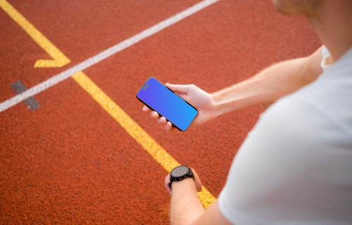 Young runner holding an iPhone 14 Pro mockup
