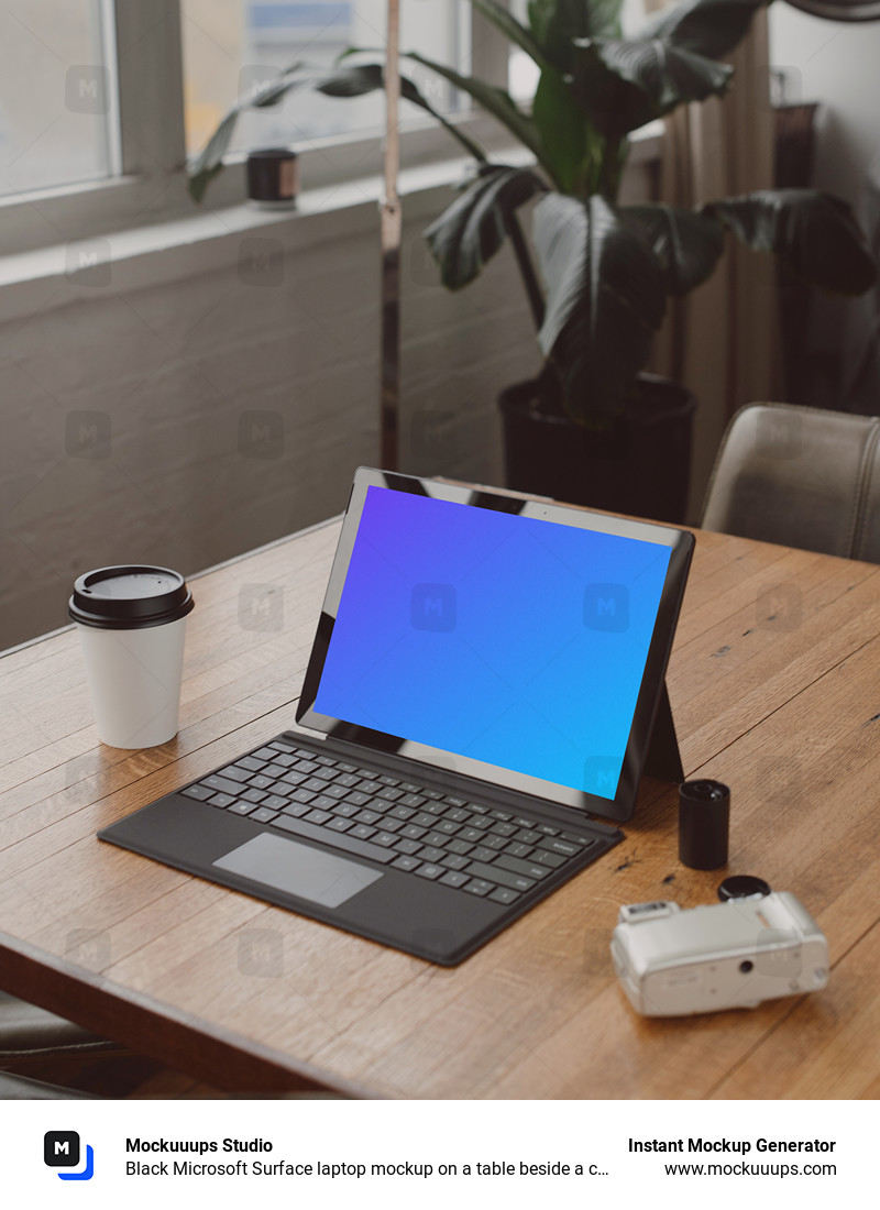 Black Microsoft Surface laptop mockup on a table beside a cup of coffee 