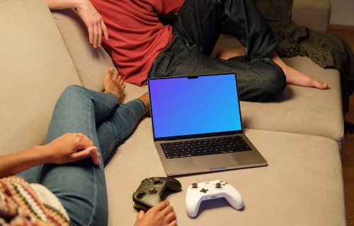 MacBook Pro Mockup on a Cozy Sofa with Game Controllers