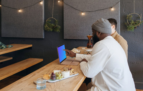 Microsoft Surface Laptop mockup in a restaurant with two users