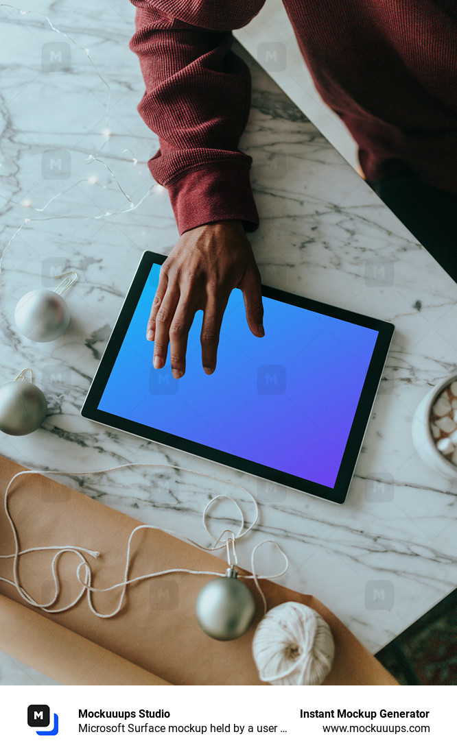 Microsoft Surface mockup held by a user on a marble table