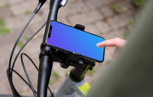 Tapping sur l'iPhone 11 Pro mockup dans un support pour vélo avec le guidon sur le côté.