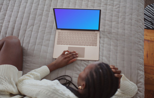 Une femme travaillant sur le Microsoft Surface Laptop mockup depuis son lit