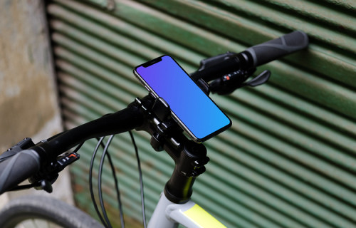 Vélo appuyé contre un garage avec un iPhone 11 Pro mockup dans un support de vélo
