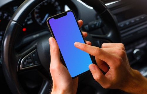 Un conducteur tapote son iPhone 11 mockup devant son volant