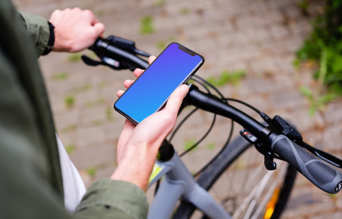 Tenir un iPhone 11 Pro mockup en attendant un vélo