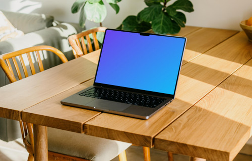 MacBook Pro gratuit mockup sur une table avec une plante en arrière-plan