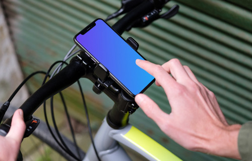 Homme à vélo près d'un garage avec un iPhone 11 Pro mockup dans un support de vélo