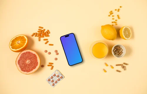 Phone surrounded by pills and citrus fruits