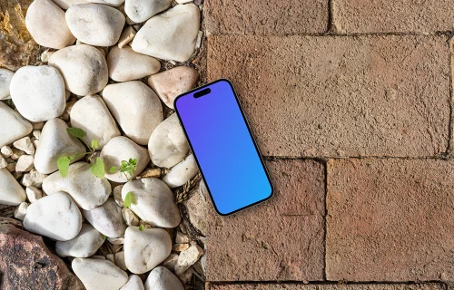 Smartphone mockup laying on a brick path