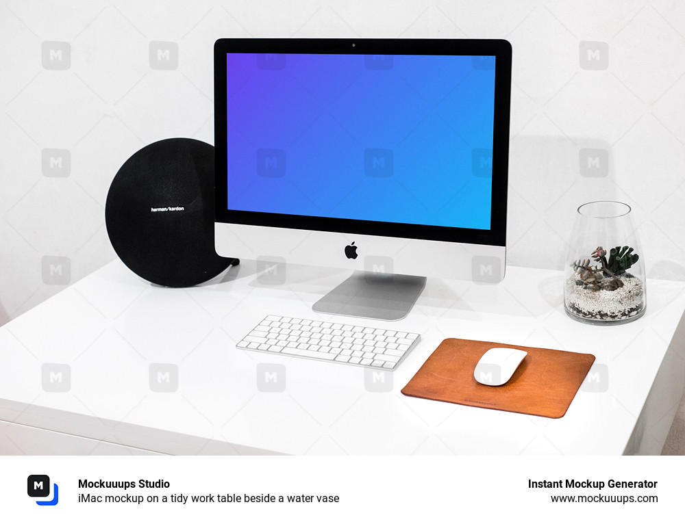 iMac mockup sur une table de travail bien rangée à côté d'un vase d'eau