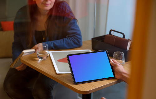 Hand holding an iPad Air mockup in office