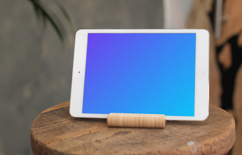 iPad Mini mockup in landscape mode placed on a wooden stool