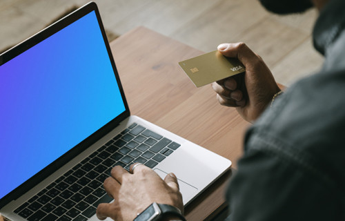 Homme effectuant un paiement en ligne avec une carte Visa sur son ordinateur MacBook mockup.
