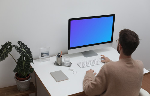 Utilisateur utilisant un iMac à son poste de travail