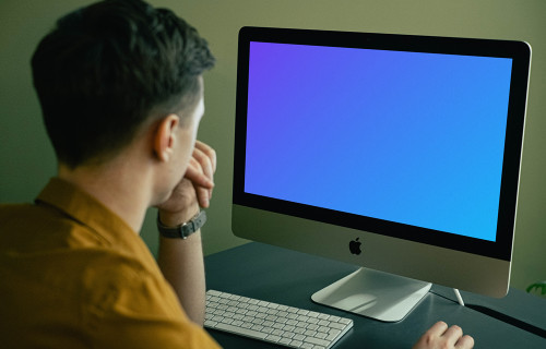 Mockup d'un utilisateur regardant fixement son iMac lorsqu'il travaille