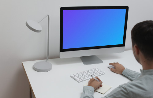 Mockup utilisateur utilisant un iMac et écrivant dans un bloc-notes