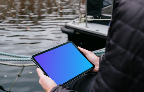 iPad Air mockup held by a user beside a river