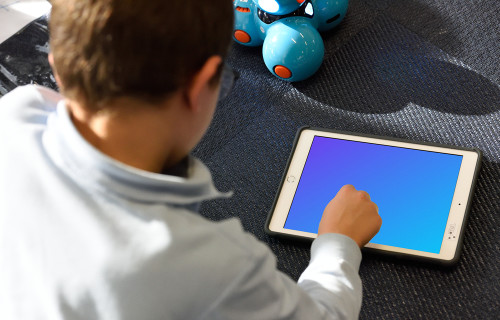 Enfant utilisant un iPad mockup avec un jouet à côté